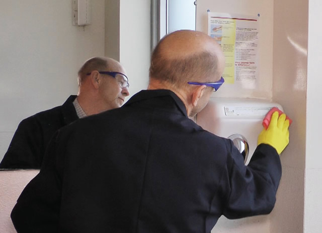 custodian cleaning wall