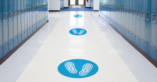 Social distancing markers on school hallway. 