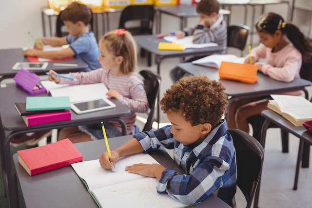 Elementary students in a classroom working at their desks. 