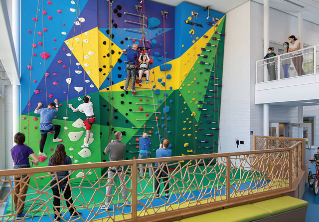 colorful rockwall feature at school with students climbing